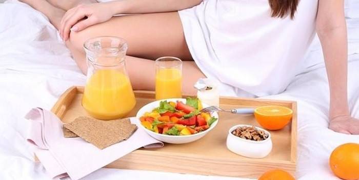 Chica en la cama con desayuno