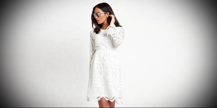 Chica en un vestido de punto de encaje blanco