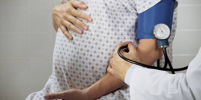 Medic mede a pressão arterial em uma mulher grávida