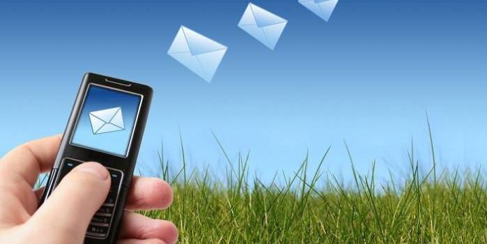 Telefone na mão e envelopes voadores
