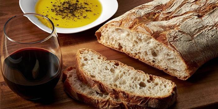 Ciabatta, um copo de vinho e azeite com especiarias