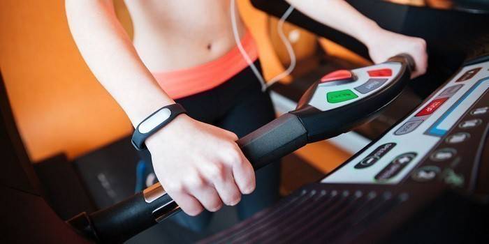 Dziewczyna trenuje z bransoletką fitness na nadgarstku