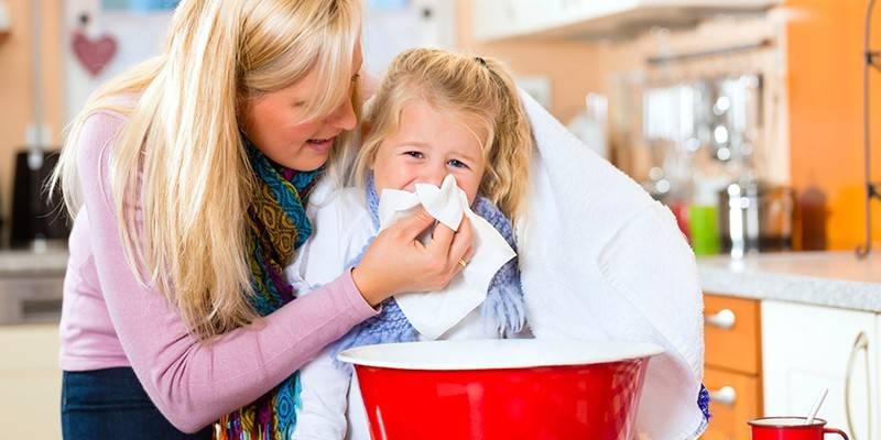 La mujer hace la inhalación del bebé