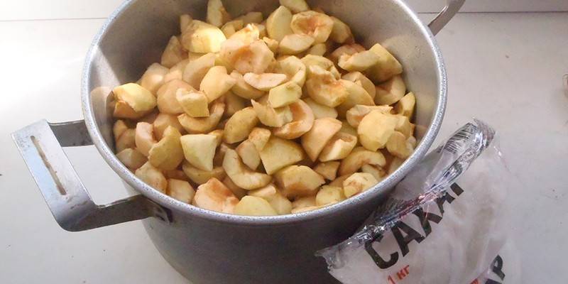 Maçãs descascadas em uma panela e açúcar
