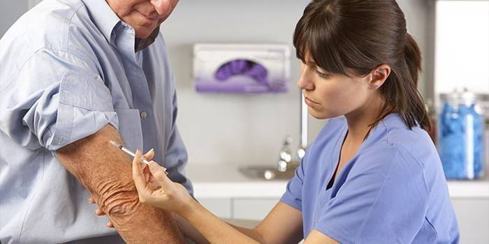 Medic dá uma injeção a um homem