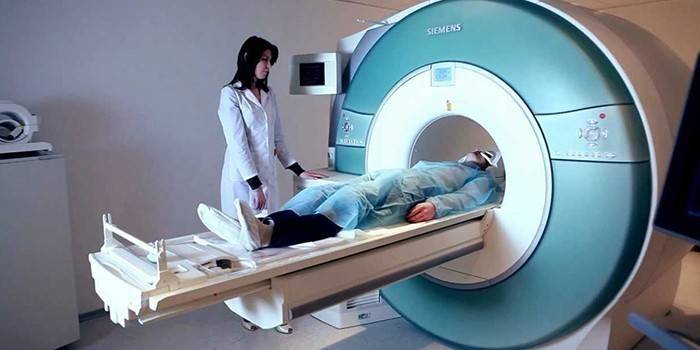 Um homem em uma máquina de ressonância magnética e um médico nas proximidades