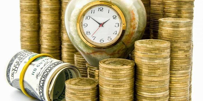 Relógio, notas e colunas de moedas