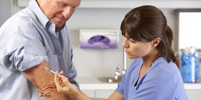 Medic faz uma injeção no antebraço