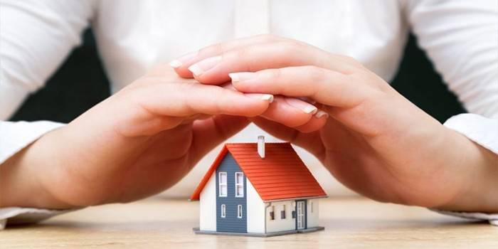 La niña cruzó los brazos sobre la casa.