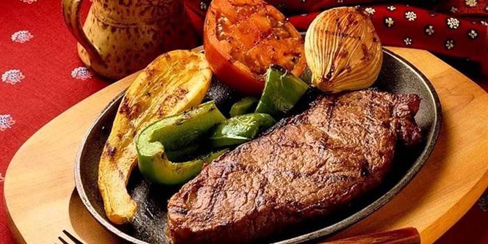 Lengua de ternera con verduras a la plancha en un plato