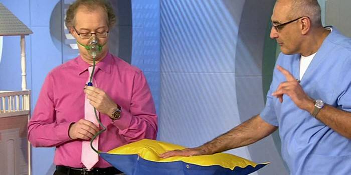 Um homem usa um travesseiro de oxigênio