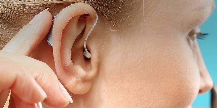 Audífono detrás de la oreja en el oído de una niña