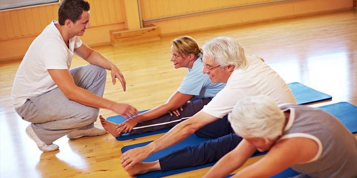 Pessoas fazendo terapia de exercício com um treinador