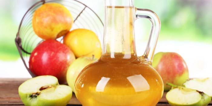 Vinagre de manzana con una jarra de vidrio y manzanas