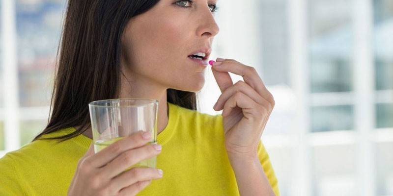 Mujer toma una pastilla