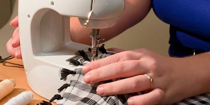 Mulher costura em uma máquina de escrever