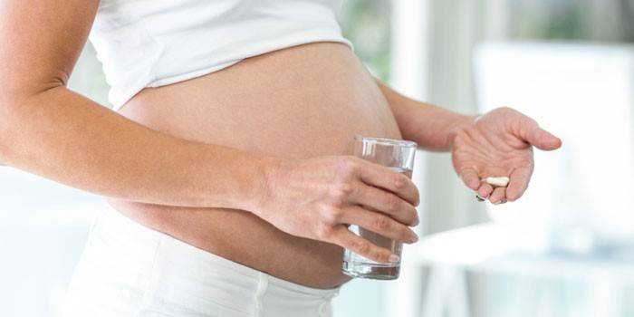 Mulher grávida, com, cápsulas, e, um, vidro água, em, dela, mãos