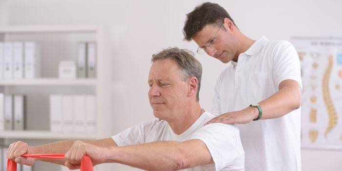 Um homem liderado por um médico está envolvido em terapia de exercícios