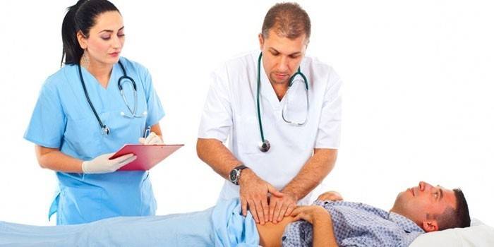 O médico mantém uma palpação do abdome