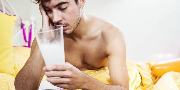 Homem com uma ressaca está bebendo um coquetel.