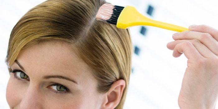 Garota coloca uma máscara no cabelo dela