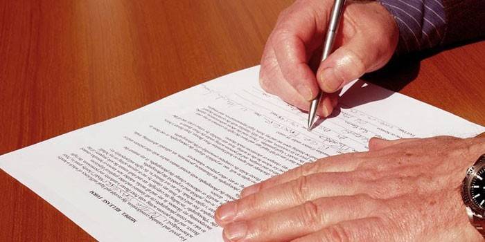 El hombre firma un documento
