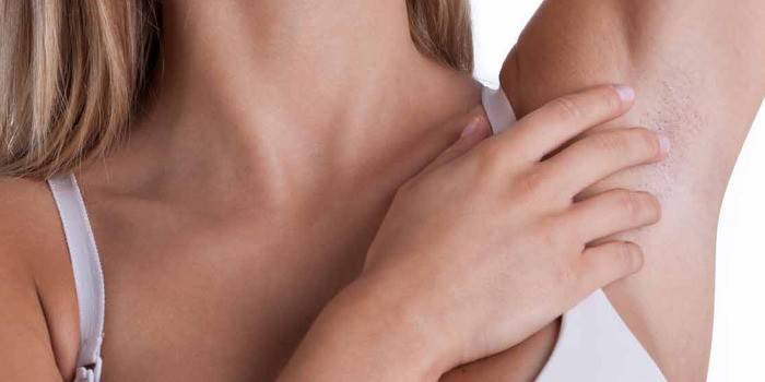 Mujer examina las axilas en busca de focas