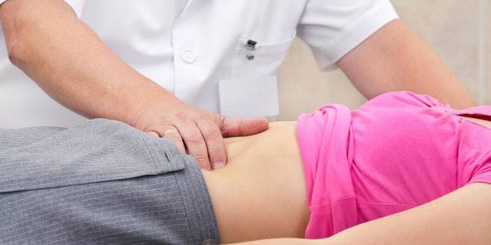 O médico palpa o estômago do paciente