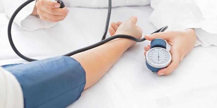 El médico mide la presión arterial con un tonómetro.