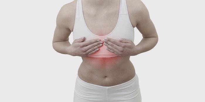 La mujer tiene dolor en el pecho.