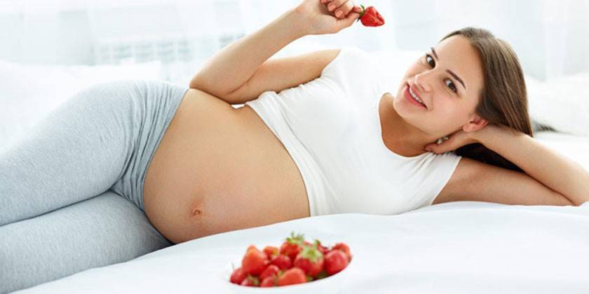 Mujer embarazada con fresas