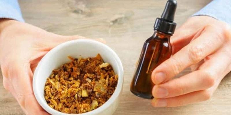 Propolis a fľaša s tekutinou v rukách človeka