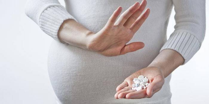 Embarazada con pastillas en la mano
