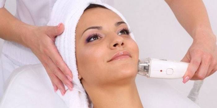 Una mujer recibe un aparato de vacío masaje facial