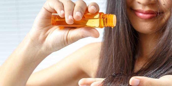 Garota coloca óleo no cabelo dela