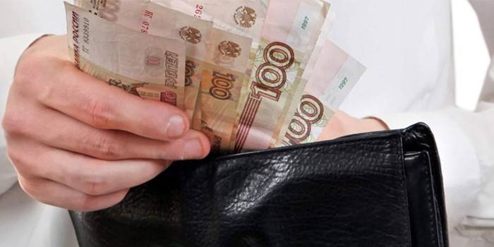 Muž vyberie peniaze z peňaženky